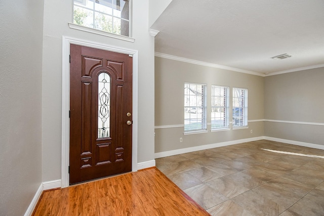 foyer featuring crown molding, plenty of natural light, and light wood-type flooring