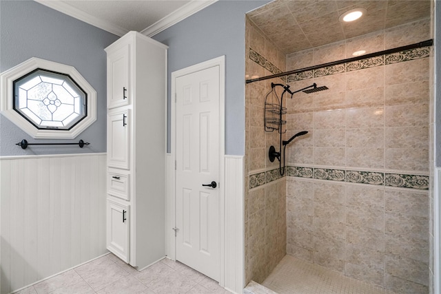 bathroom with tile patterned floors, ornamental molding, and tiled shower