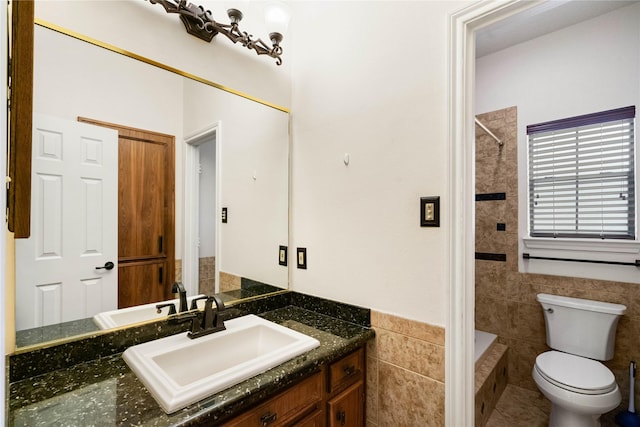 bathroom with vanity, toilet, and tile walls