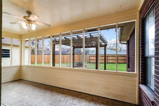 unfurnished sunroom featuring ceiling fan