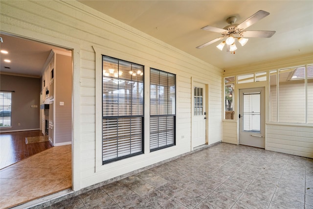 unfurnished sunroom featuring ceiling fan