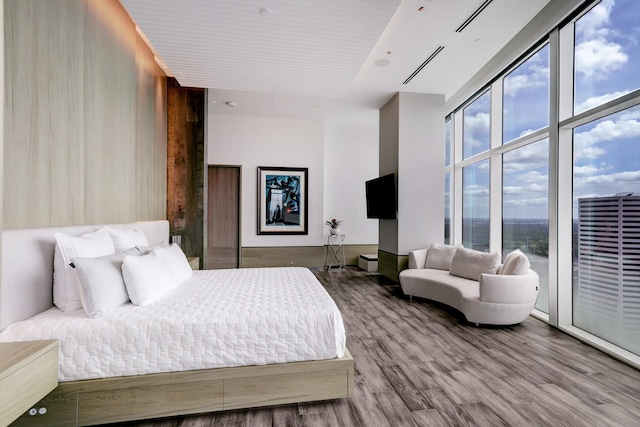 bedroom with floor to ceiling windows and wood-type flooring