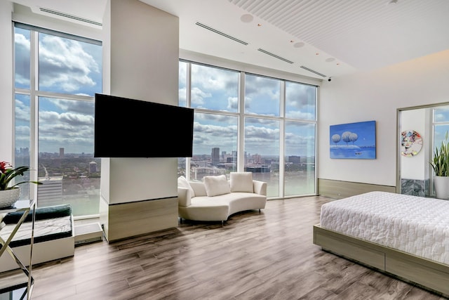 bedroom featuring vaulted ceiling, hardwood / wood-style floors, and multiple windows