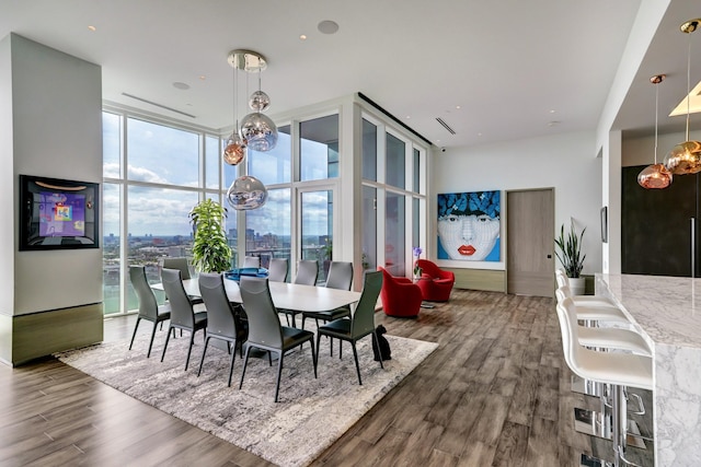 dining space with dark hardwood / wood-style floors, an inviting chandelier, and a wall of windows