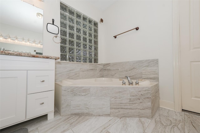 bathroom featuring vanity and tiled tub