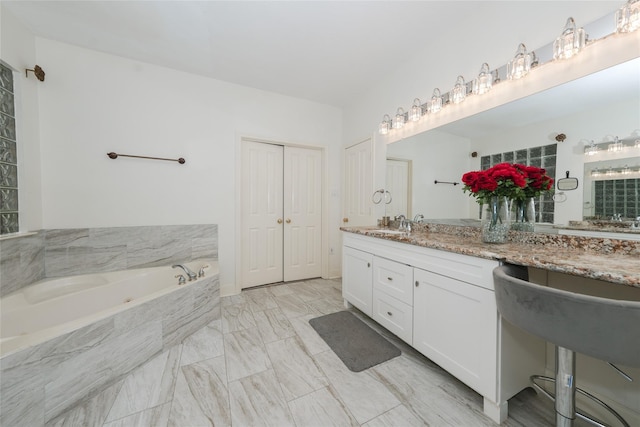 bathroom with vanity and tiled bath