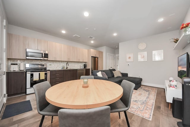 dining room featuring sink and light hardwood / wood-style floors