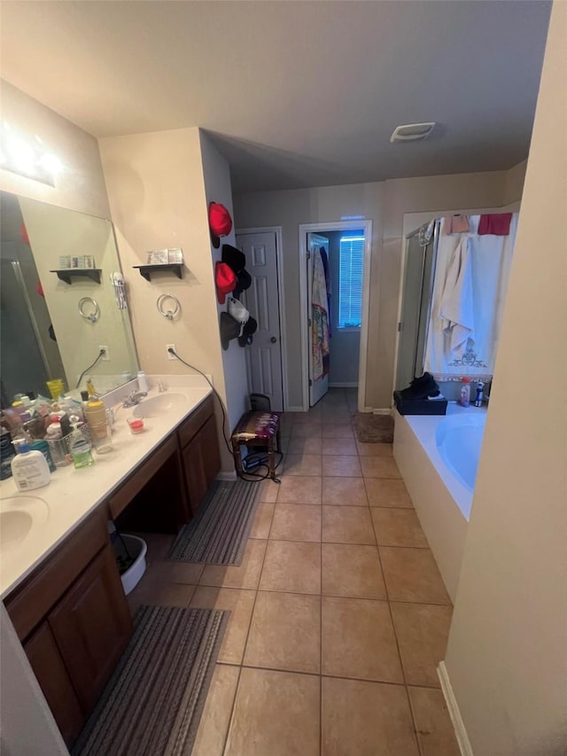 bathroom featuring vanity, a bath, and tile patterned floors