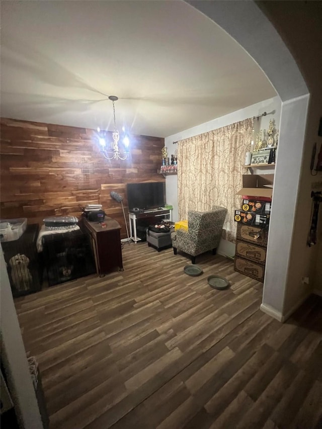 interior space featuring dark hardwood / wood-style floors, a chandelier, and wood walls