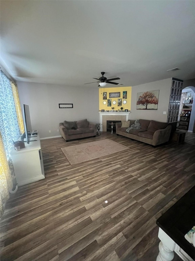 living room with ceiling fan and dark hardwood / wood-style flooring