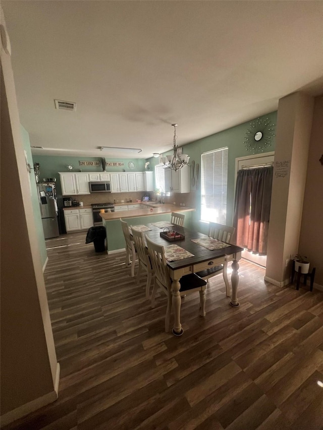 dining room with an inviting chandelier and dark wood-type flooring