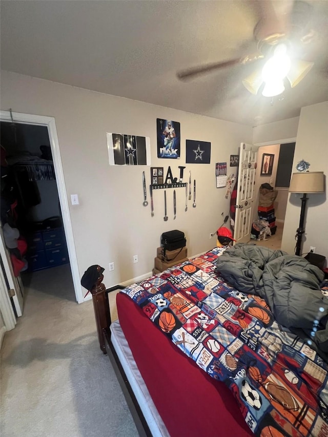 carpeted bedroom featuring ceiling fan, a walk in closet, a closet, and a textured ceiling