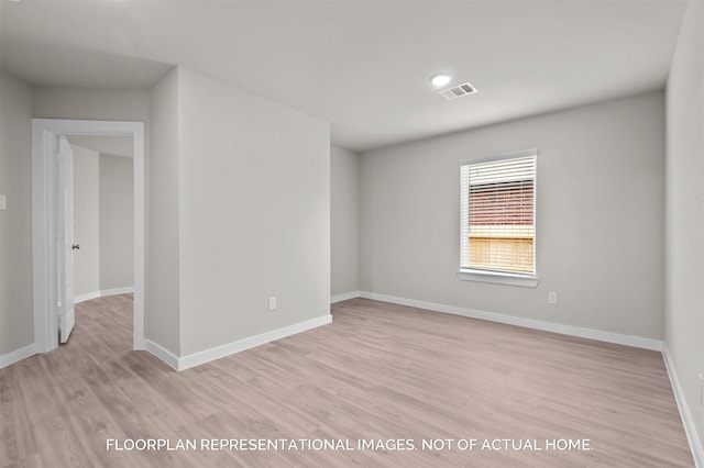 unfurnished room featuring visible vents, light wood-style flooring, and baseboards