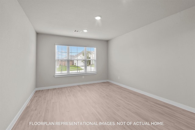 empty room with visible vents, baseboards, and wood finished floors