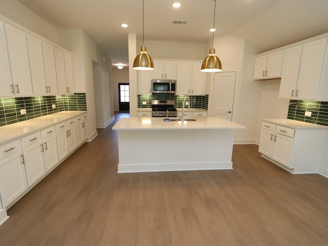 22478 Birchfield Grove Ln, New Caney, TX 77357 - kitchen featuring appliances with stainless steel finishes, backsplash, a sink, white cabinetry, and recessed lighting
