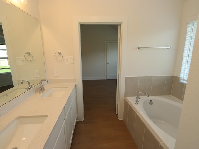 22478 Birchfield Grove Ln, New Caney, TX 77357 - bathroom featuring wood finished floors, double vanity, and a garden tub