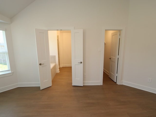 22478 Birchfield Grove Ln, New Caney, TX 77357 - unfurnished bedroom with wood finished floors, vaulted ceiling, and baseboards