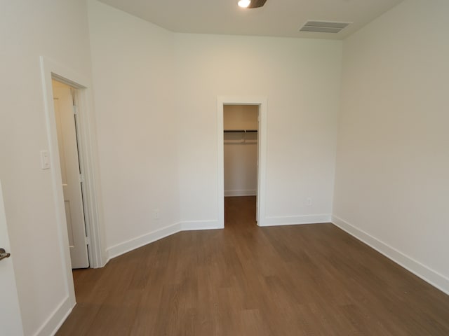 22478 Birchfield Grove Ln, New Caney, TX 77357 - unfurnished bedroom featuring dark wood finished floors, baseboards, a walk in closet, and a closet