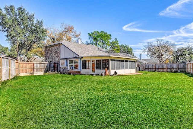 rear view of property with a sunroom and a yard