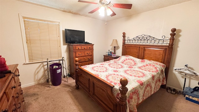 carpeted bedroom featuring ceiling fan and a textured ceiling