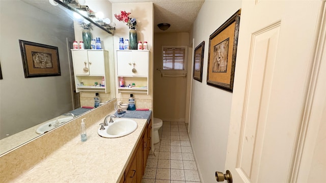 bathroom with vanity, tile patterned floors, a textured ceiling, and toilet