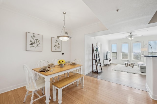 dining space featuring crown molding, hardwood / wood-style flooring, and ceiling fan