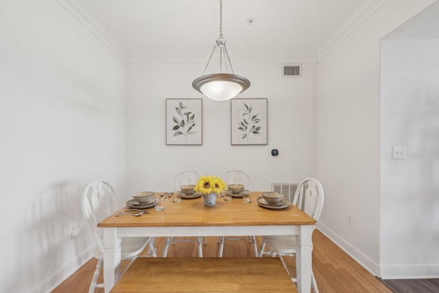 dining space featuring crown molding and wood-type flooring