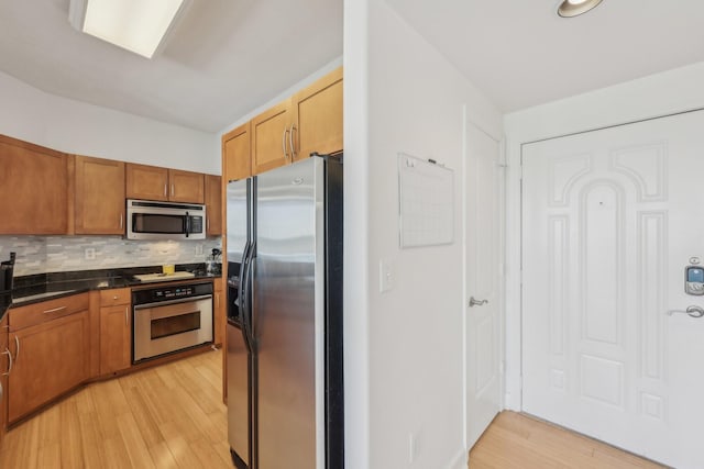 kitchen featuring backsplash, light hardwood / wood-style floors, and appliances with stainless steel finishes