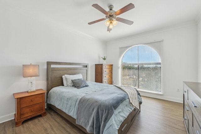 bedroom featuring ornamental molding, ceiling fan, and dark hardwood / wood-style flooring