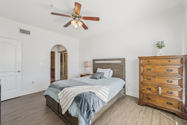 bedroom with crown molding, ceiling fan, and hardwood / wood-style flooring