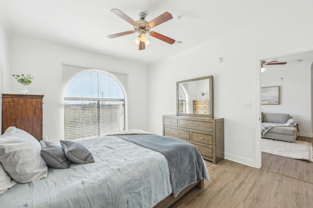 bedroom featuring crown molding, ceiling fan, and light wood-type flooring