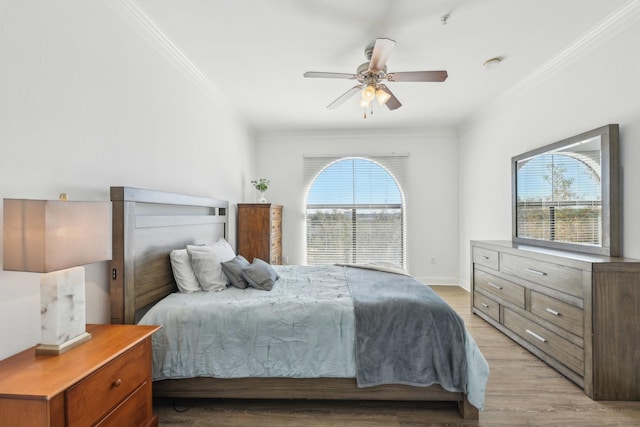 bedroom featuring ceiling fan, ornamental molding, and light hardwood / wood-style flooring