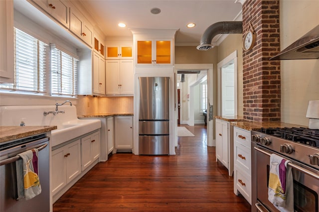 kitchen featuring stainless steel appliances, extractor fan, light stone countertops, and white cabinets