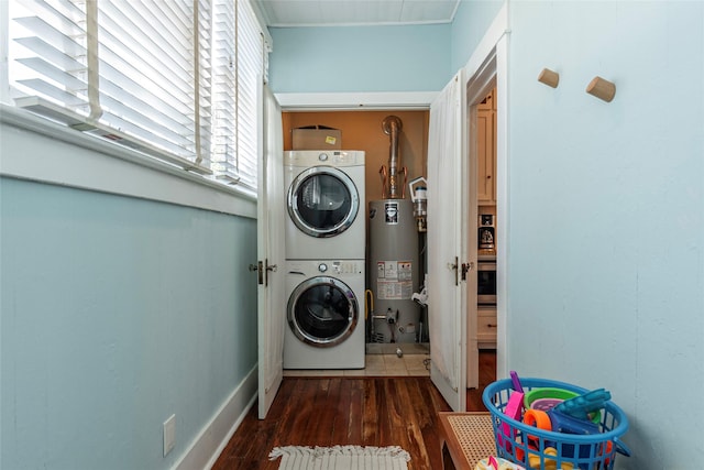 washroom featuring stacked washer and dryer, dark hardwood / wood-style floors, and water heater