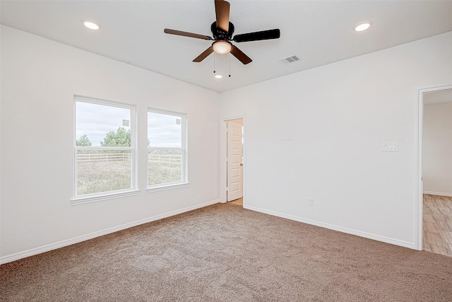 spare room with ceiling fan and light carpet