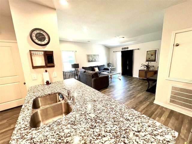 kitchen featuring light stone counters, dark hardwood / wood-style floors, sink, and vaulted ceiling