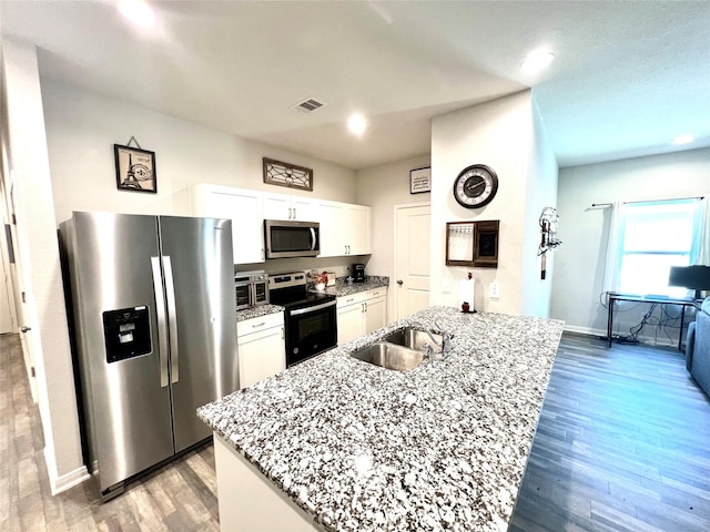 kitchen featuring sink, a center island with sink, white cabinets, and appliances with stainless steel finishes