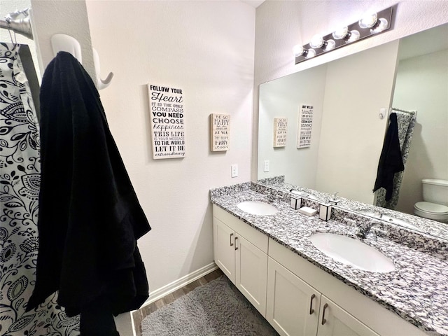 bathroom featuring wood-type flooring, toilet, and vanity