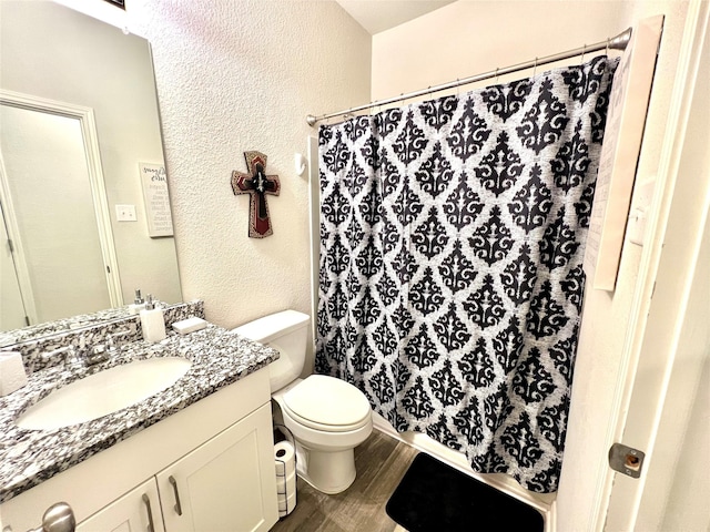 bathroom with vanity, wood-type flooring, toilet, and walk in shower