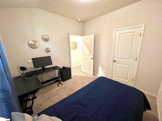 bedroom with light colored carpet and vaulted ceiling