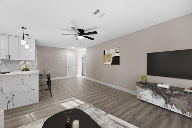 living room with ceiling fan and light hardwood / wood-style floors