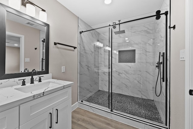 bathroom with vanity, a shower with door, and wood-type flooring