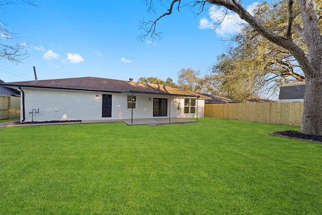 rear view of property featuring a patio area and a lawn