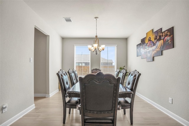 dining room featuring wood-type flooring and a notable chandelier