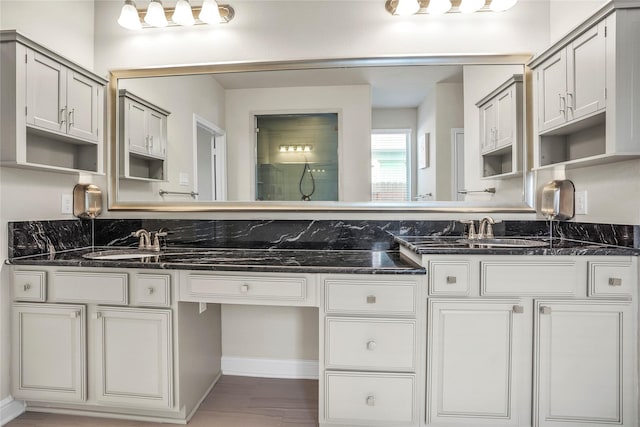 kitchen with sink, dark stone counters, and white cabinets