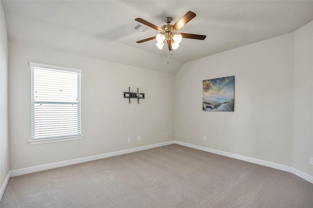 spare room with ceiling fan, lofted ceiling, and carpet flooring