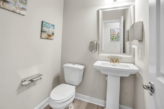 bathroom with hardwood / wood-style flooring, sink, and toilet