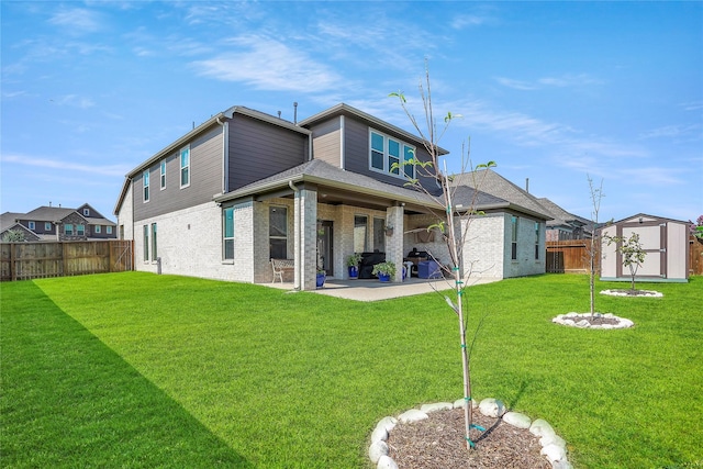 rear view of property featuring a patio area, a lawn, and a storage unit