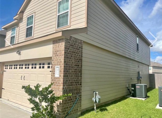 view of home's exterior with cooling unit and a garage