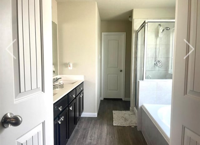 bathroom featuring shower with separate bathtub, wood-type flooring, and vanity